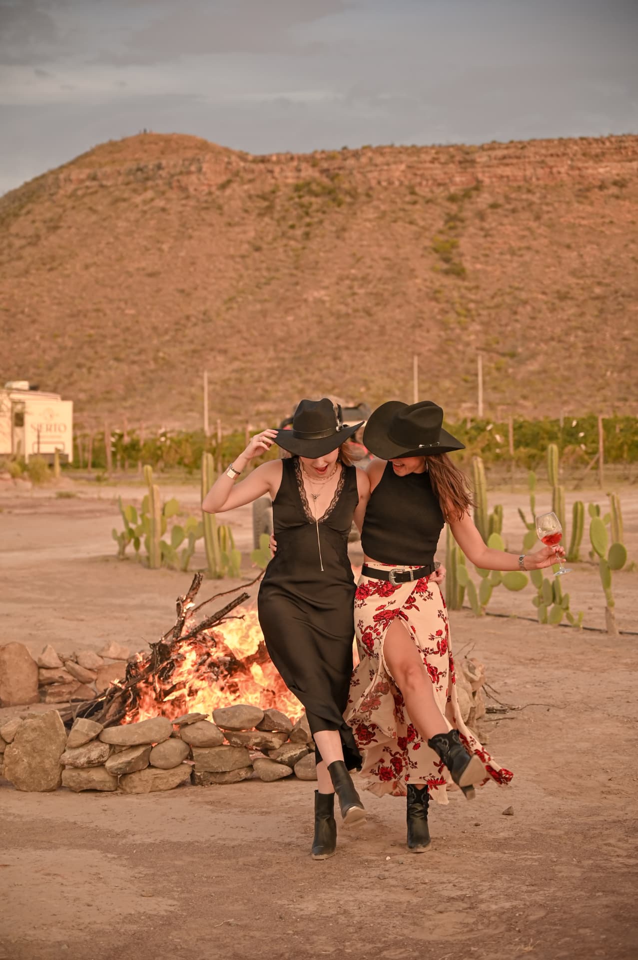 Amigas celebrando junto a la fogata al atardecer